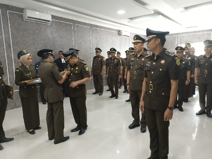 Kajari Zainul Arifin Syah memasang lecana tanda jabatan kepada Kasi Pidum Maruli Tua Johanes Sitanggang usai disumpah di Aula Kantor Kejari Jalan Pertanian, Bengkalis, Kamis (9/3/2023).